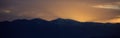 Sunset/sunrise over dark mountains silhouettes