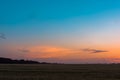 Sunset sunrise over field or meadow. Bright dramatic sky and dark ground Royalty Free Stock Photo