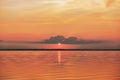 Sunset or sunrise in sea, nature landscape background, red orange clouds flying in sky to shining sun above water Royalty Free Stock Photo