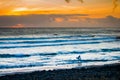 Sunset Surfer leaving cool Atlantic under a red sunset sky