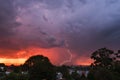 Sunset thunderstorm view from park over the city with bolts and