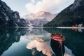 Sunset time. Wooden boat on the crystal lake with majestic mountain behind. Reflection in the water. Chapel is on the Royalty Free Stock Photo