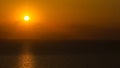 Sunset timelapse view: yellow bright sun disc on natural orange sky background with sun beams and rays of light Royalty Free Stock Photo