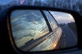 Sunset in a traffic jam on the road through the right side mirror in the car Royalty Free Stock Photo