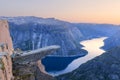 Sunset on Trolltunga - famous landmark in Norway. Panoramic view of fjord lake and mountains, summer landscape Royalty Free Stock Photo