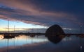 Sunset at twilight over Morro Bay Harbor boats and Morro Rock on the central California coast in California USA Royalty Free Stock Photo