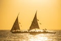 Sunset with two dhows in a distance. Dhows are wooden sailing boats mostly used in the indian ocean used to transport Royalty Free Stock Photo