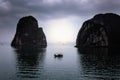 Sunset view of a boat between two of the spectacular rocks of Ha Long Bay Royalty Free Stock Photo