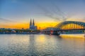 Sunset view of the cathedral in Cologne and Hohenzollern bridge over Rhein, Germany Royalty Free Stock Photo