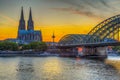 Sunset view of the cathedral in Cologne and Hohenzollern bridge over Rhein, Germany Royalty Free Stock Photo