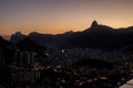 Sunset view of Christ the Redeemer on Mount Corcovado overlooking the city of Rio de Janeiro lit up at dusk down below in Brazil