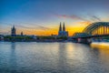 Sunset view of cityscape of Cologne with Hohenzollern bridge, cathedral and Saint Martin church, Germany Royalty Free Stock Photo