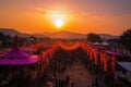 a sunset view of a colorful cultural festival, with the setting sun casting an orange glow