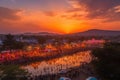 a sunset view of a colorful cultural festival, with the setting sun casting an orange glow