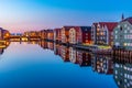 Sunset view of colorful timber houses surrounding river Nidelva in the Brygge district of Trondheim, Norway