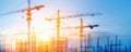 Sunset view of construction cranes on a high-rise building site, showcasing progress and development against a vibrant sky Royalty Free Stock Photo