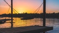 Sunset view of a dock with a hammock on it with a river and trees in the background Royalty Free Stock Photo