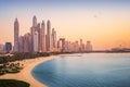 Sunset view of Dubai Marina and JBR area and the famous Ferris Wheel and golden sand beaches in the Persian Gulf. Holidays and