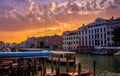 Sunset view of Grand Canal, Venice, Italy. Vaporetto or waterbus station, boats, gondolas moored by walkways, beautiful