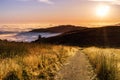 Sunset view of hiking trail in the Santa Cruz mountains; valley covered by a sea of clouds visible in the background; San Royalty Free Stock Photo