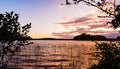 Sunset View of an island on a lake framed by silhouetted trees Royalty Free Stock Photo