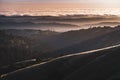 Sunset view of layered hills and valleys covered by a sea of clouds in Santa Cruz mountains ; San Francisco bay area, California