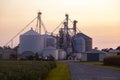 A sunset view of the modern granaries and silos of a large industrial size farm Royalty Free Stock Photo