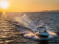 Sunset view of a motorboat cruising with speed over the ocean