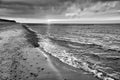 at sunset, a view over the beach in Zingst on the Baltic Sea. Walk along the sea in black and white. Moving clouds in the sky Royalty Free Stock Photo