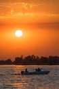 Sunset view over a river with a boat passing by and tourists making selfies Royalty Free Stock Photo