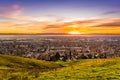 Sunset view of residential and industrial areas in East San Francisco Bay Area; green hills visible in the foreground; Hayward, Royalty Free Stock Photo