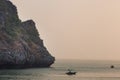 Sunset view on rock islands with fishing boat in Ha Long Bay near to Cat Ba, Vietnam Royalty Free Stock Photo