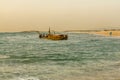 Sunset view of a rusty shipwreck in HaBonim Beach