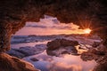 Sunset view from the sea cave. Sunset Framed by Coastal Rocks. Cyprus. Royalty Free Stock Photo