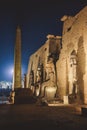 Sunset View to the Illuminated Stone Statues of the large Ancient Egyptian temple in Luxor Royalty Free Stock Photo