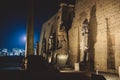 Sunset View to the Illuminated Stone Statues of the large Ancient Egyptian temple in Luxor Royalty Free Stock Photo