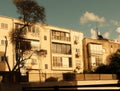 Sunset view of a vintage urban apartment building in Tel Aviv, Israel, with a silhouette of a tree and golden sunlight Royalty Free Stock Photo