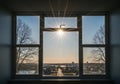 Sunset view through a window, capturing a glowing sun centered above a distant highway flanked by Royalty Free Stock Photo