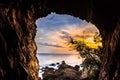 Sunset viewed through a cave by the sea Royalty Free Stock Photo