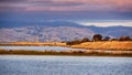 Sunset views of the restored wetlands of South San Francisco Bay Area; dark clouds covering the sky and Diablo Mountain Range Royalty Free Stock Photo