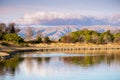 Sunset views of Shoreline Lake, with trees reflected in the calm water surface; Diablo Mountain Range visible in the background; Royalty Free Stock Photo