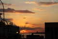 Sunset on the waterfront with the lampposts of the harbor in backlight Royalty Free Stock Photo