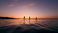 Sunset waters and a group of young friends while paddlesurfing