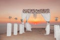 Sunset. Wedding ceremony arch with flowers decorative arrangement and white curtain on cliff above sea, sunrise outdoor summer ph Royalty Free Stock Photo