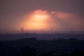 Sunset with wind turbines in a distant landscape Royalty Free Stock Photo