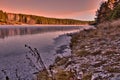 sunset in the winter forest. forest on the banks of the frozen river. ice on the river Royalty Free Stock Photo