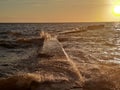 at sunsetthe old pier flooded with waves Royalty Free Stock Photo