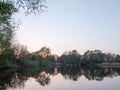 Sunsetting over a lake as the trees around are reflected in the