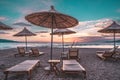 Sunshade beach umbrellas with sunset sky and sea background. Sarande, Albania