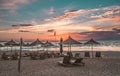 Sunshade beach umbrellas with sunset sky and sea background. Sarande, Albania